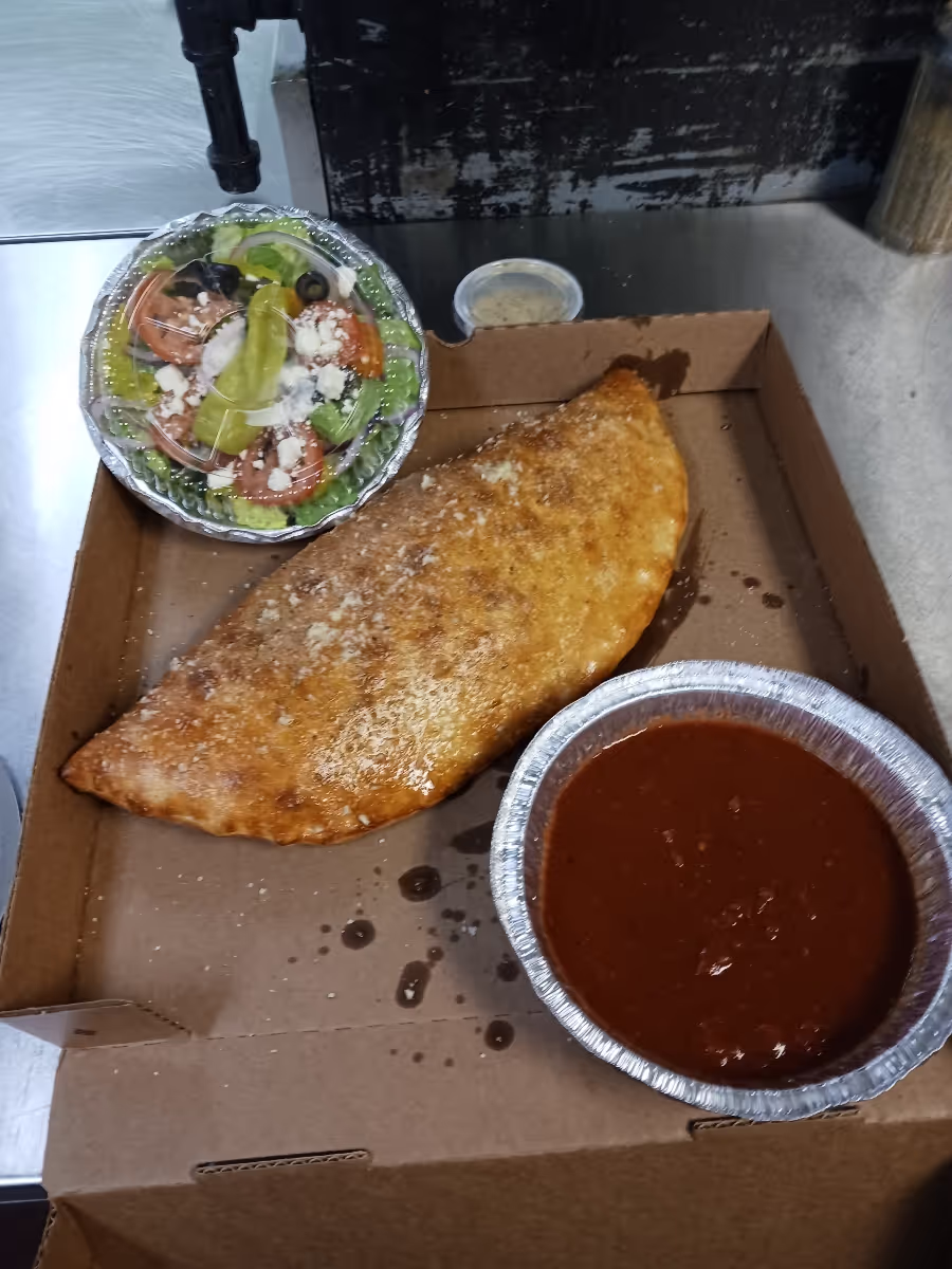 calzone with salad and sauce on the side